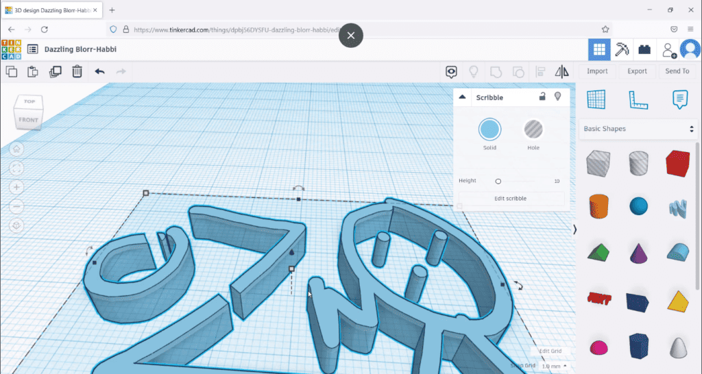 A screenshot of a 3D design project in Tinkercad featuring various shapes on a grid and the 'Scribble' tool selected in the right-hand menu.